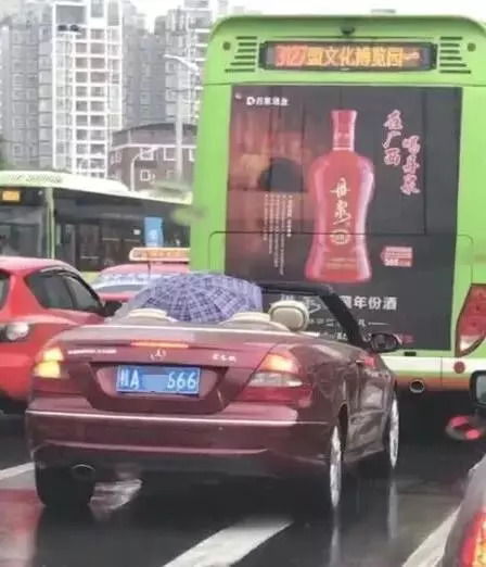 拉风下雨天打伞开敞篷车南宁奔驰撑伞哥表情包刷屏了